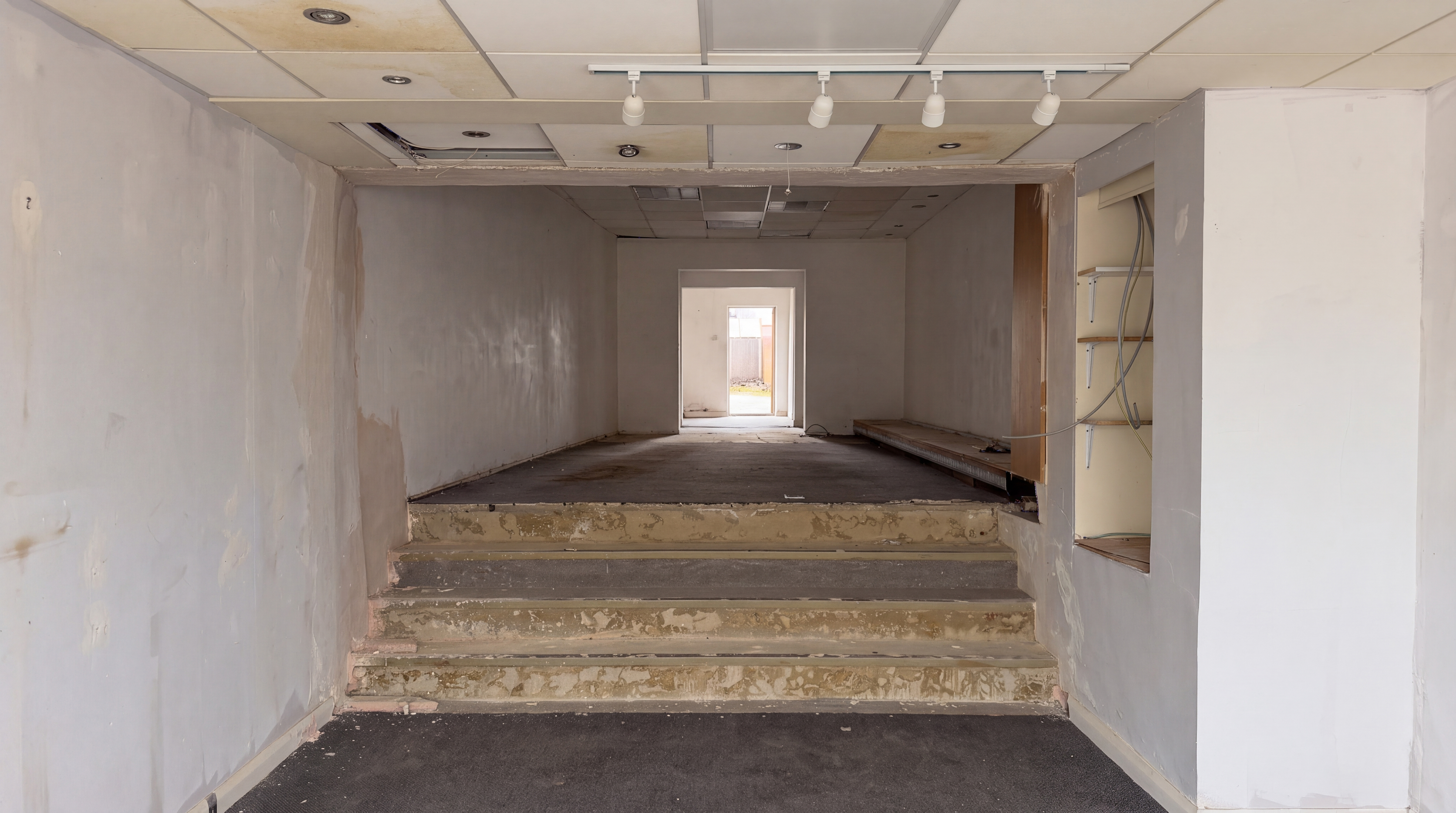 Room before renovation — bare plastered walls and worn floors